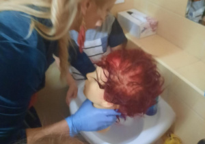 Pani Kasia myje główkę w umywalce po farbowaniu.
