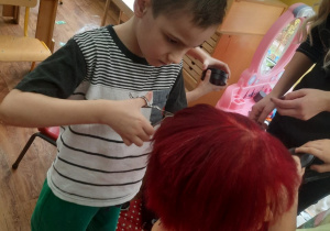 Chłopiec podcina włosy na główce do ćwiczeń.