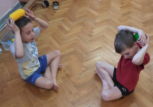 Dzieci na sali bawią się piłkami sensorycznymi.