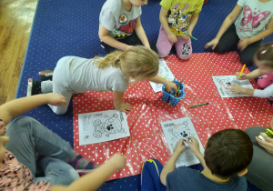 Na dywanie dzieci wykonują zadanie z misiem.
