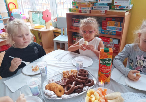 dziewczynki przy stoliku zjadają różne potrawy