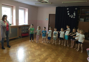 Dzieci stoją w rzędzie na sali gimnastycznej.