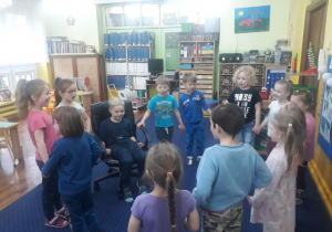 Dzieci ustawione w kole śpiewają "100 lat".