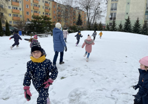 Dzieci biegają po śniegu.