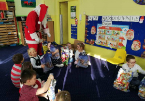 Święty Mikołaj rozdaje dzieciom z grupy IV prezenty.