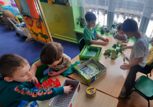 Dzieci przy stolikach grają w gry planszowe.