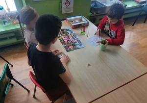 Dzieci przy stolikach grają w gry planszowe.