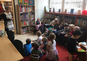 Dzieci siedzą w bibliotece.