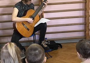 Uczennica gra na gitarze.