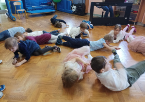 dzieci turlają się na podłodze