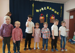 dzieci z grupy 2 prezentują piosenkę, w tle napis "Wielkanoc 2023".