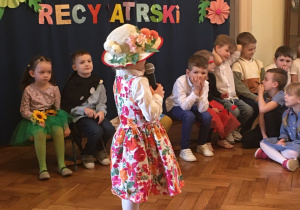 Dziewczynka recytuje swój wiersz przed publicznością.