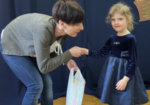 Dziewczynka otrzymuje nagrodę za udział w konkursie plastycznym "Ekologiczna ozdoba wielkanocna".