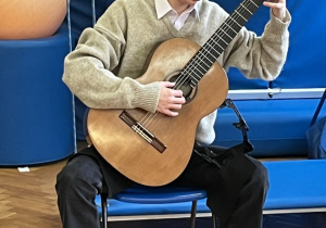 Uczeń szkoły muzycznej gra na gitarze.