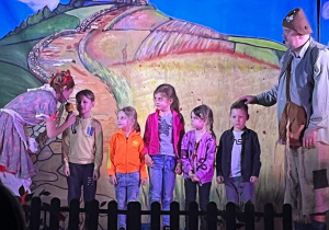 Na scenie znajdują się aktorzy wraz z wybranymi dziećmi z sali.