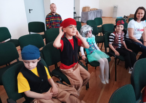 dzieci przebrane za piratów, siedzą na krzesłach na dużej sali