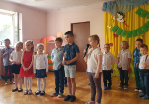 Grupa dzieci recytuje wiersz.
