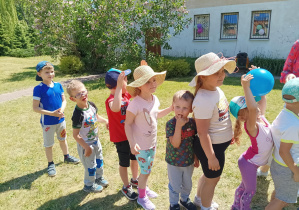 dzieci biorą udział w konkurencji sportowej w ogródku przedszkolnym
