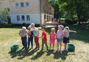 dzieci biorą udział w konkurencji sportowej w ogródku przedszkolnym