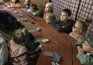 Dzieci siedzą przy stole, a przed nimi leżą szmatki.
