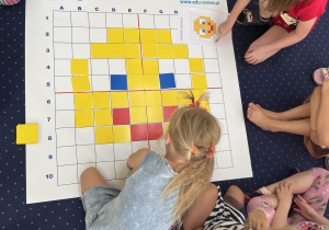 Dzieci układają kolorowe karteczki zgodnie z kodem.