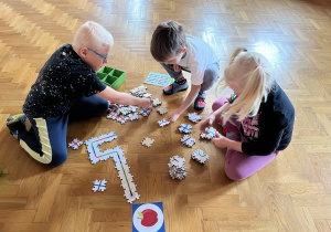 Dzieci wykonują drogę z puzzli dla ozobota.