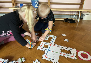 Dzieci wykonują drogę z puzzli dla ozobota.