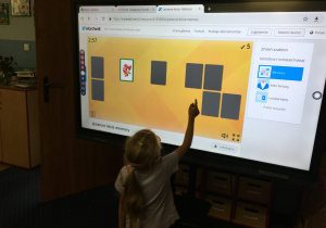 Dzieci wykonują zadanie na tablicy multimedialnej.