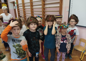 grupa dzieci w czapkach, wiankach- elementach stroju ludowego