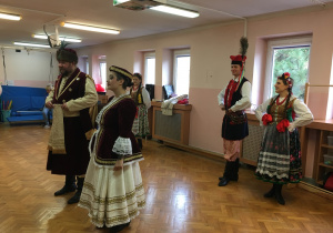 dzieci na sali gimnastycznej oglądają strój krakowski i szlachecki