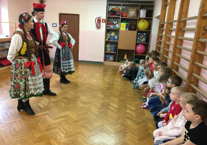 dzieci na sali gimnastycznej oglądają strój krakowski