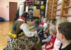 dzieci na sali gimnastycznej oglądają strój krakowski
