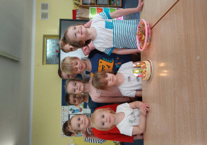 dzieci stoją za stolikiem, na którym widać zabawkowy. urodzinowy tort