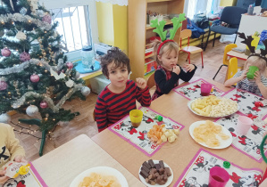 dzieci przy wspólnym słodkim posiłku z okazji mikołajek