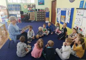 Dzieci z grupy IV słuchają bajkę pt. "Kopciuszek" czytana przez babcię Helenki.