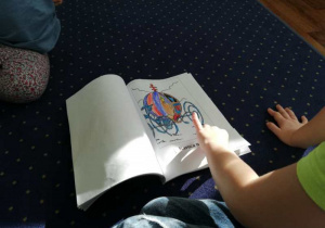 Dziecko ogląda książeczkę przez nas stworzoną.