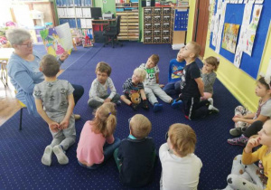 Dzieci z grupy IV słuchają bajkę pt. "Kopciuszek" czytana przez babcię Helenki.