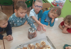 dzieci ozdabiają upieczone ciasteczka