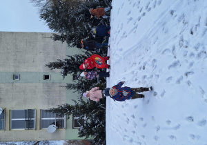dzieci bawią się na śniegu na górce w ogródku przedszkolnym