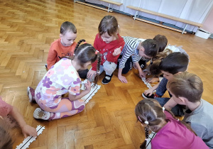 dzieci siedzą na podłodze i układają wzór dla ozobota