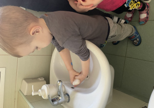chłopiec myje ręce w łazience