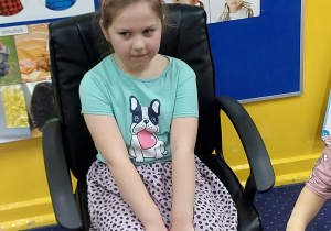 Dziewczynka siedzi na krześle.