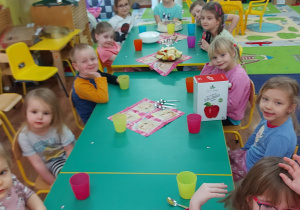 Dzieci siedzą przy stole.