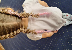 Dziewczynka prezentuje swoją fryzurę.