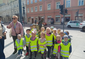 grupa dzieci w żółtych kamizelkach pozują do zdjęcia na ul. Piotrkowskiej