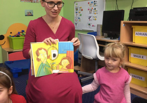 Mama Zosi prezentuje dzieciom książkę.