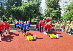 Dzieci stoją ustawione w rzędach.