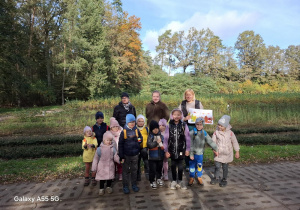 grupa dzieci pozuje do zdjęcia na tle jesiennego lasu