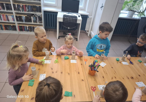 dzieci w bibliotece wykonują prace plastyczne