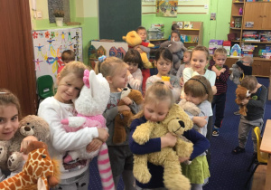 Dzieci przytulaja się do swoich misiów.